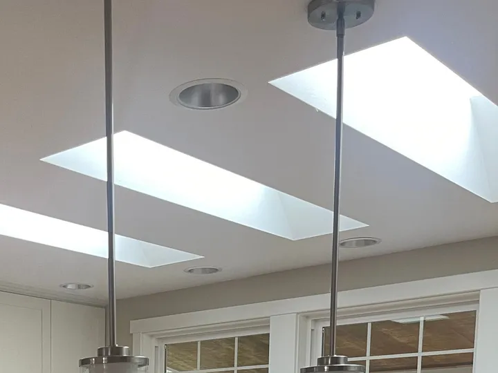 Bright kitchen with skylights and pendant lights in a home Rosy cleaned