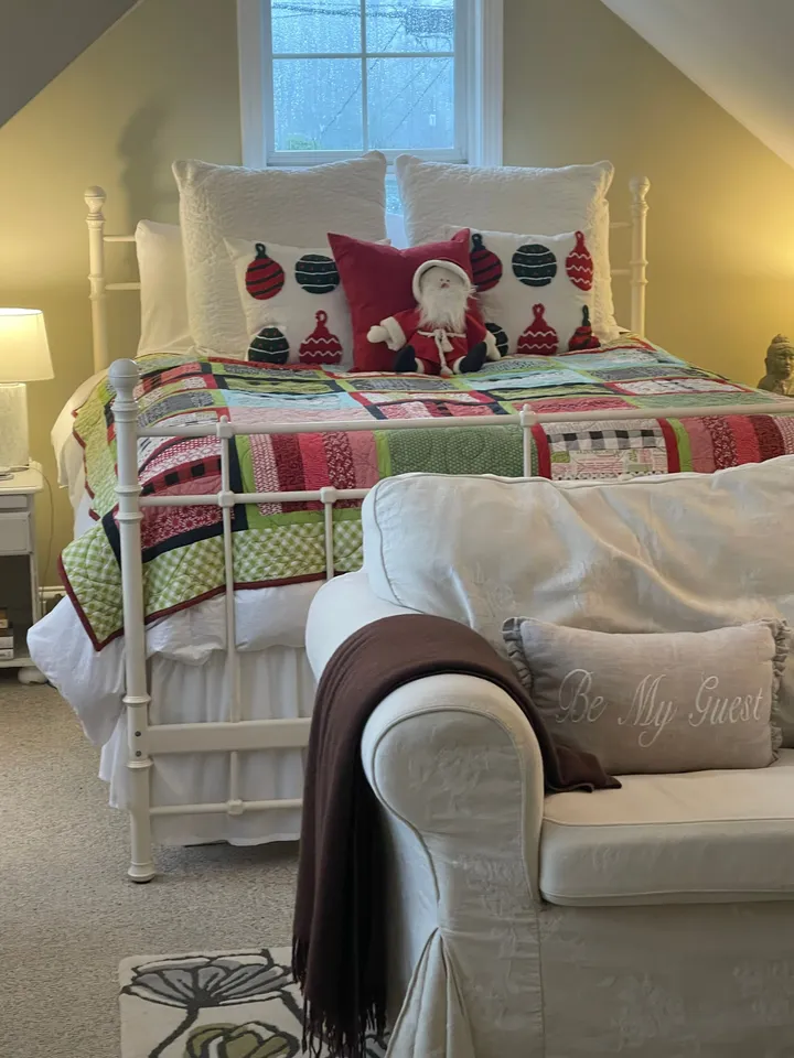 Guest bedroom with a made bed in a home Rosy cleaned, decorated for the holidays
