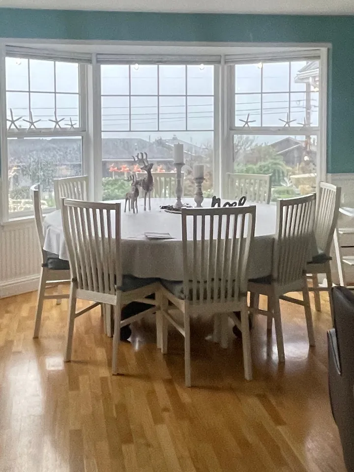 Dining nook with a bay window and hardwood floor in a home Rosy cleaned