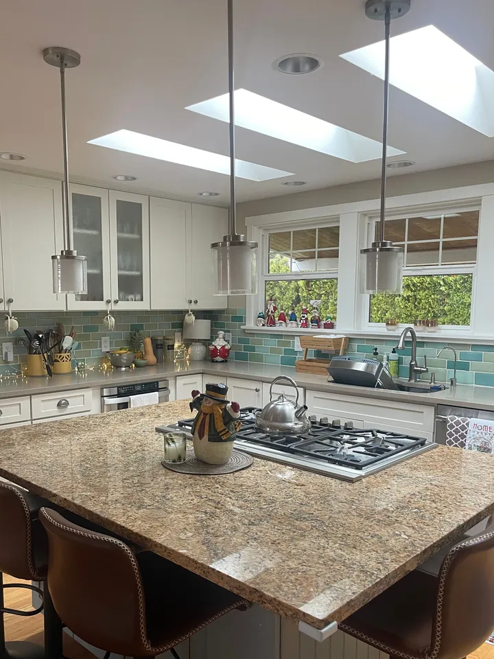 Kitchen island, cooktop and skylights in a home Rosy cleaned