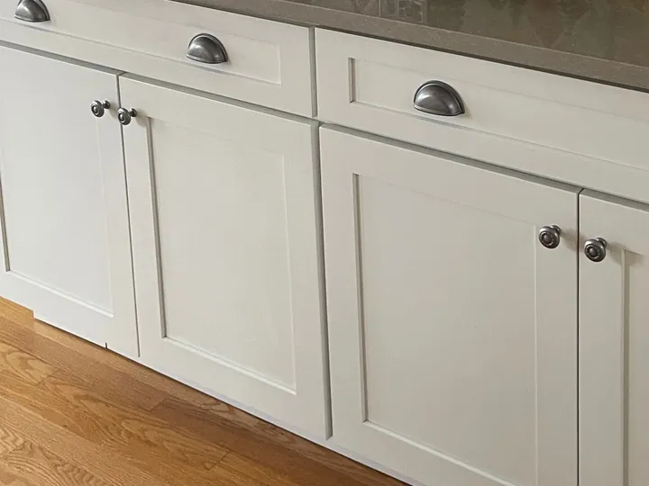 Clean white shaker cabinets and hardwood floor in a kitchen Rosy cleaned