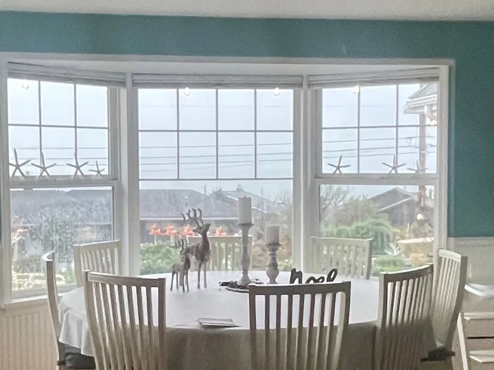 Bright dining nook with a round table and bay window in a home Rosy cleaned