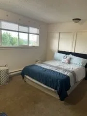 Bedroom with a navy comforter, cleaned by Rosy
