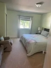 Bedroom with a floral bedspread, cleaned by Rosy