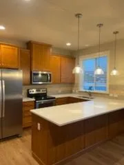 Kitchen with wood cabinets and pendant lights, cleaned by Rosy