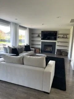 Living room with a white sofa and fireplace, cleaned by Rosy