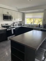 Kitchen with a dark island, cleaned by Rosy