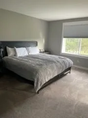 Bedroom with a gray bed, cleaned by Rosy