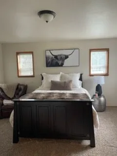 Bedroom with a dark bed frame, cleaned by Rosy