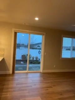 Empty room with a sliding door and wood floor, cleaned by Rosy