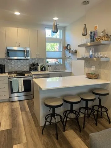 White kitchen with bar stools, cleaned by Rosy